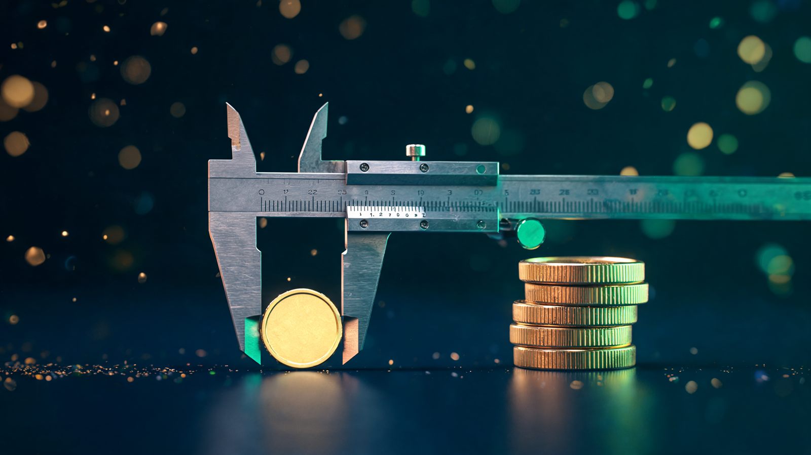 A precision caliper measuring a single small gold coin beside a short stack of coins on a dark polished surface